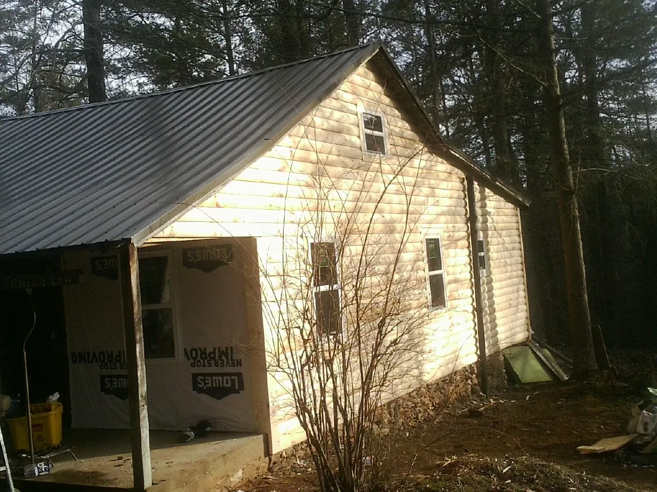 Log siding gable end under a dark metal roof edge in Sheffield